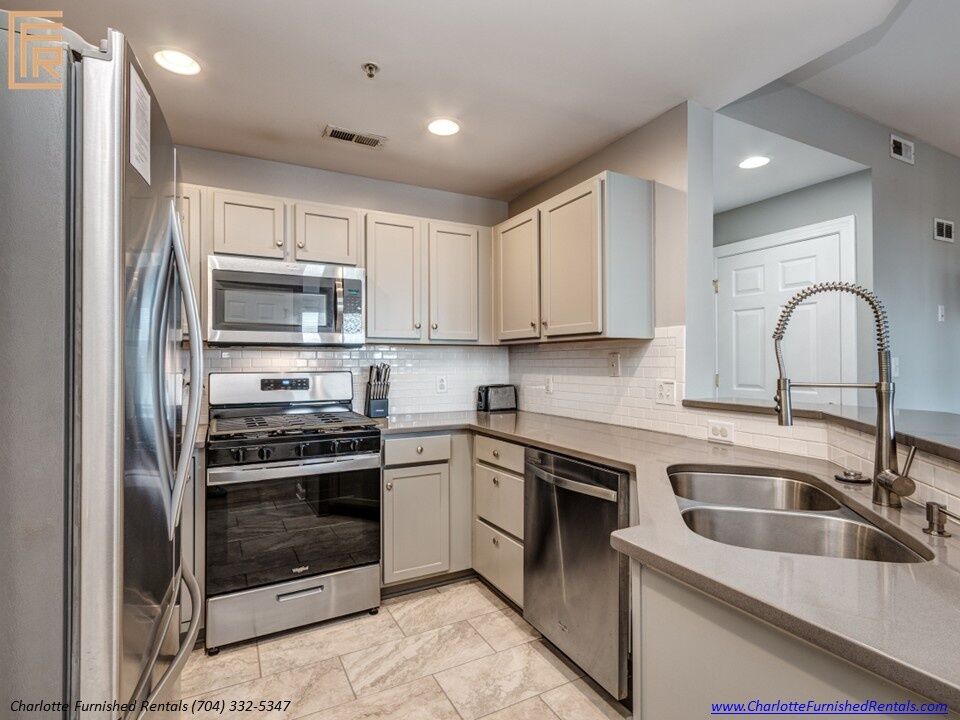 718-west-trade-unit-813-kitchen-with-stainless-appliances-uptown-charlotte Kitchen with stainless appliances at 718 West Trade Street Unit 813, a furnished rental in Uptown Charlotte