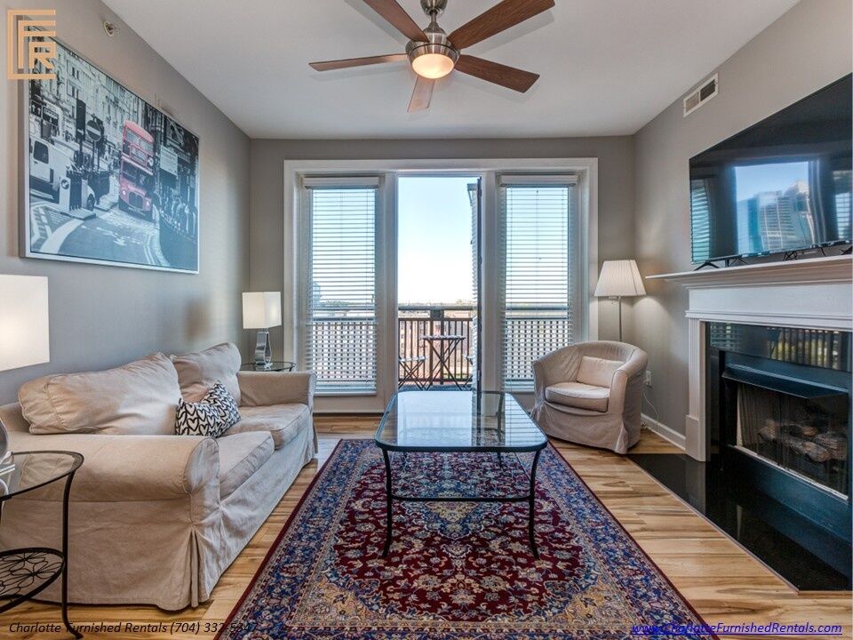 718-west-trade-unit-813-living-room-with-balcony-access-third-ward Living room with balcony access at 718 West Trade Street Unit 813, a furnished rental in Third Ward / Uptown Charlotte