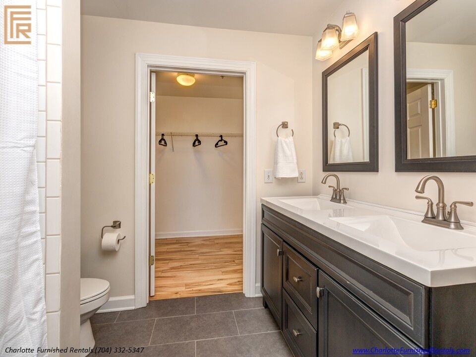 718-west-trade-unit-813-primary-bathroom-dual-vanity-and-walk-in-closet-uptown-charlotte Primary bathroom dual vanity and walk-in closet at 718 West Trade Street Unit 813, a furnished rental in Uptown Charlotte