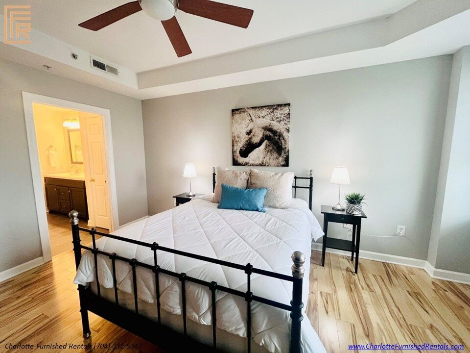 718-west-trade-unit-813-primary-bedroom-with-ensuite-bath-uptown-charlotte Primary bedroom with ensuite bath at 718 West Trade Street Unit 813, a furnished rental in Uptown Charlotte