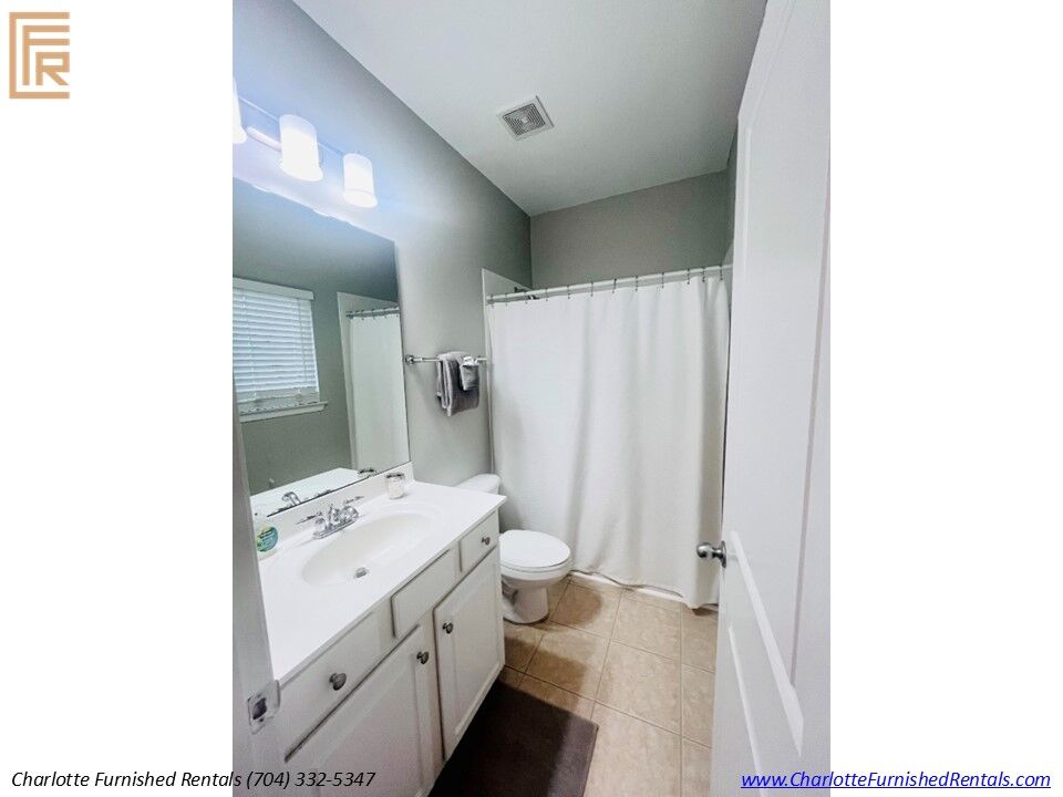 Slide10 Updated bathroom with tub and shower combination and modern finishes. Full bathroom with vanity, tiled shower, and fresh linens.
