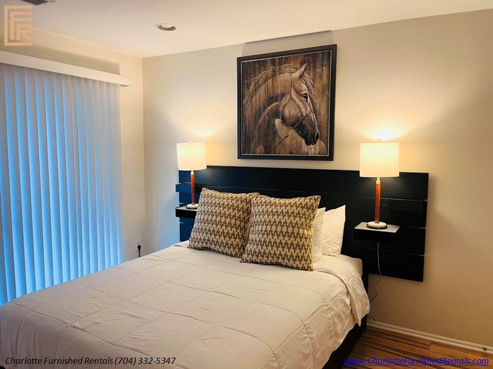 Comfortable queen bedroom with bedside lighting and hardwood floors. Queen Bedroom | 2510 Cranbrook Lane Unit 20