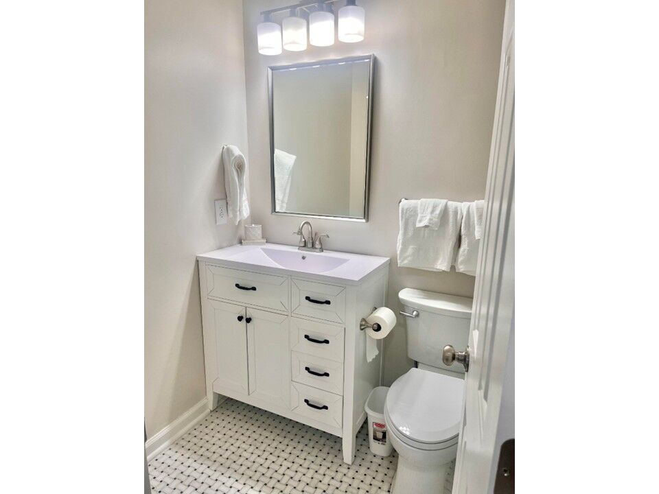 Renovated Primary Bathroom Vanity Updated primary bathroom featuring custom vanity, modern lighting and premium finishes.