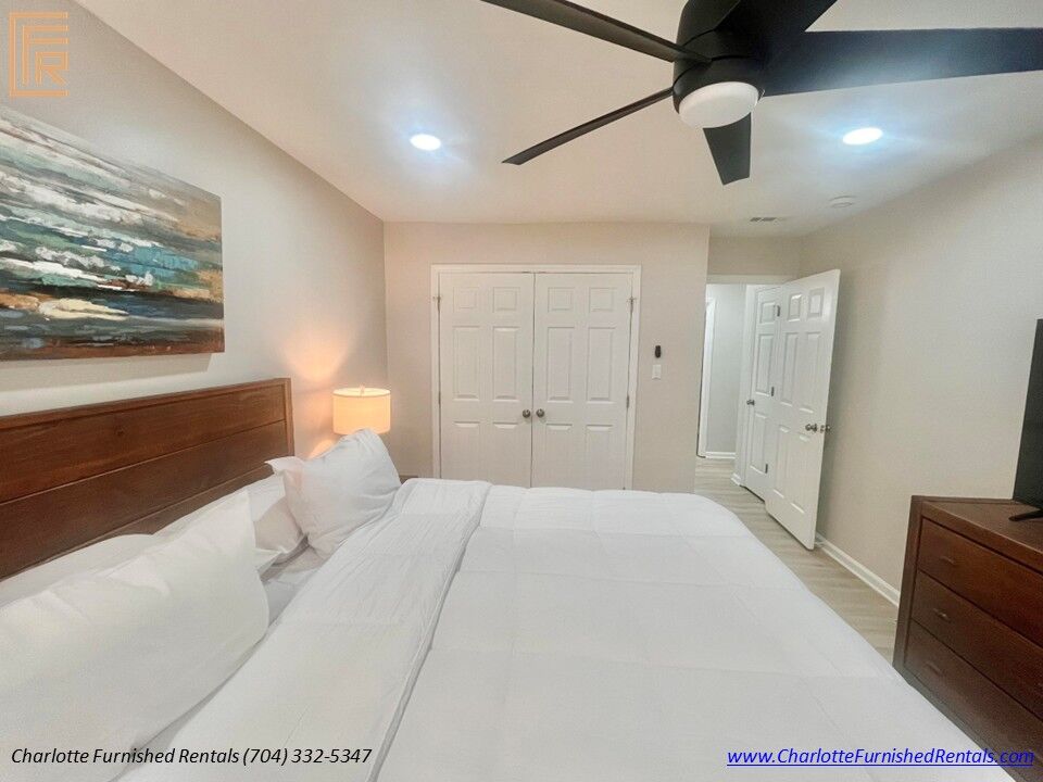 Guest Bedroom with King Bed Comfortable guest bedroom with king bed, smart TV and large windows in furnished Charlotte rental.