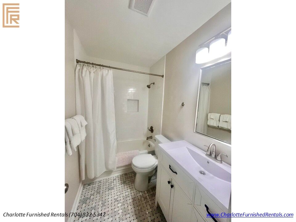 Renovated Primary Bathroom Vanity Updated primary bathroom featuring custom vanity, modern lighting and premium finishes.