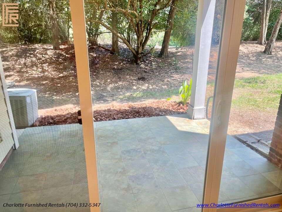 Covered Private Patio Covered outdoor patio overlooking mature landscaping at furnished SouthPark Charlotte home.