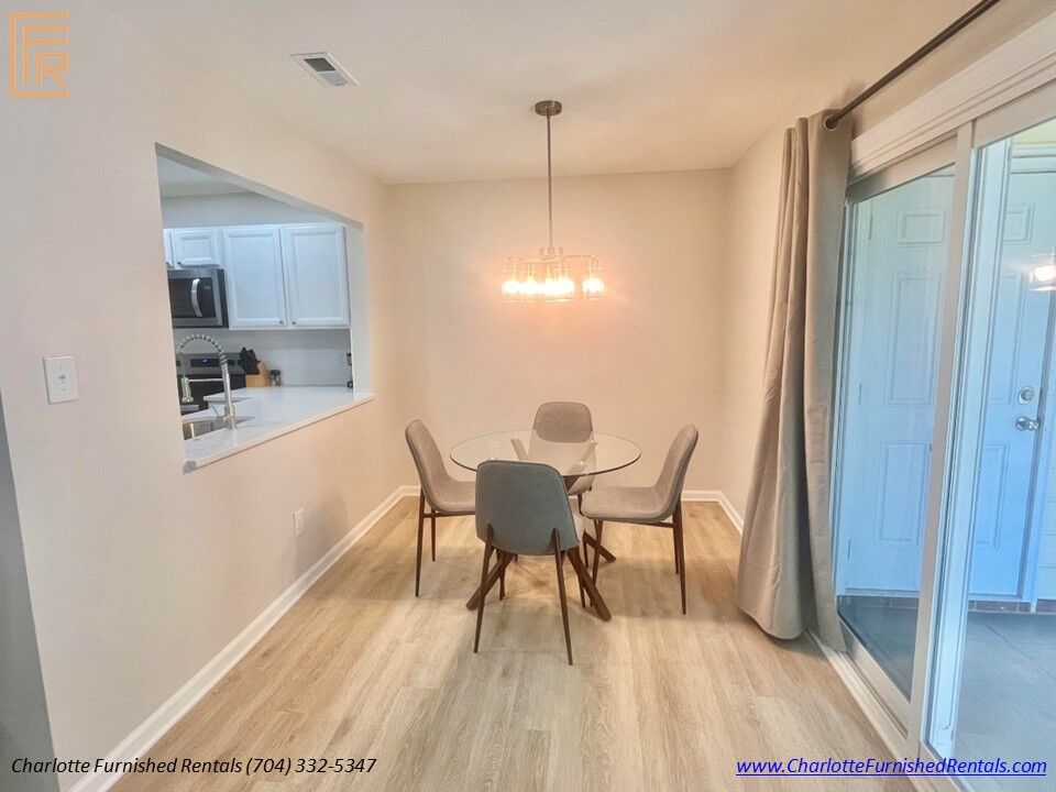 Dining Area with Patio Access Dining room with seating for four overlooking the covered patio at furnished Charlotte rental.