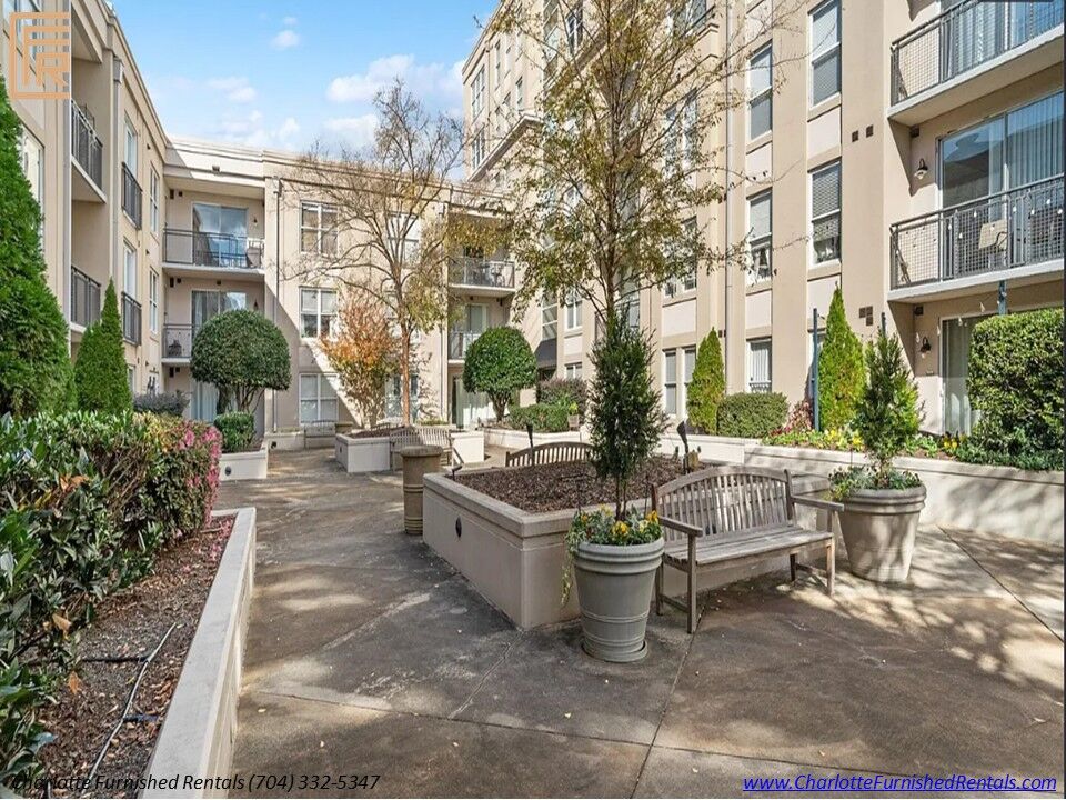 22-1315-east-blvd-courtyard-seating-charlotte Courtyard seating with benches, planters, and landscaped apartment surroundings at 1315 East Boulevard.