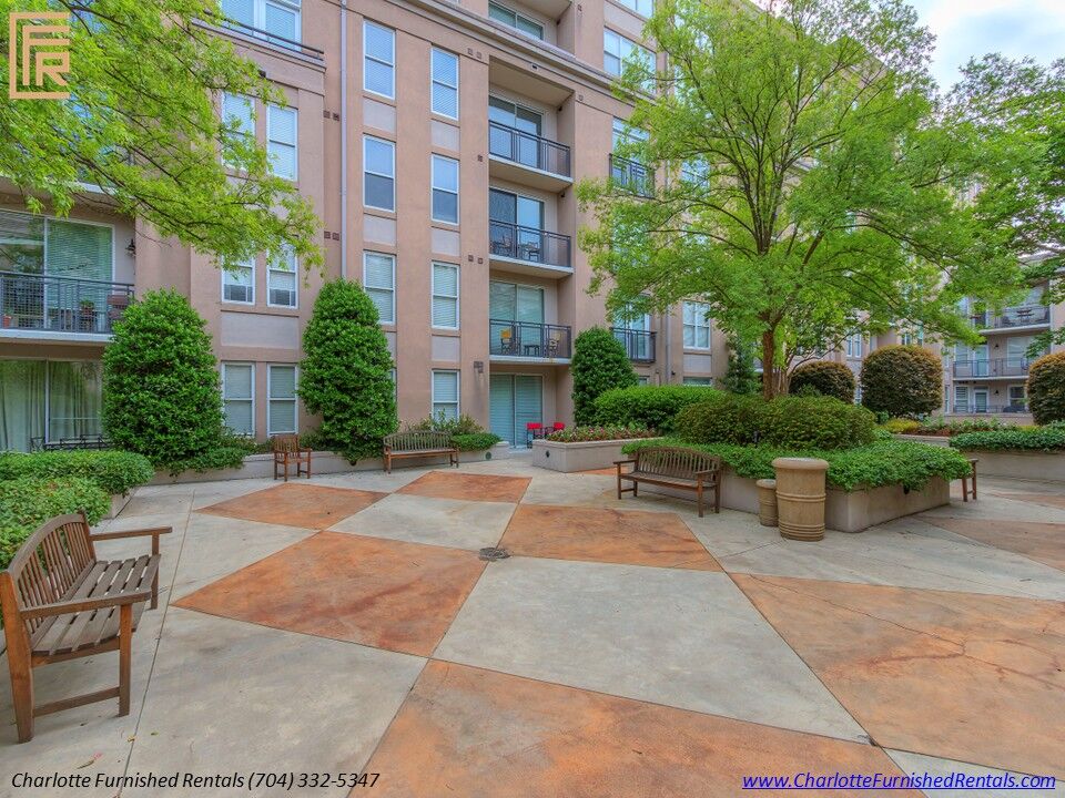 24-1315-east-blvd-outdoor-courtyard-seating Open courtyard with benches, mature trees, and landscaped planters at 1315 East Boulevard.